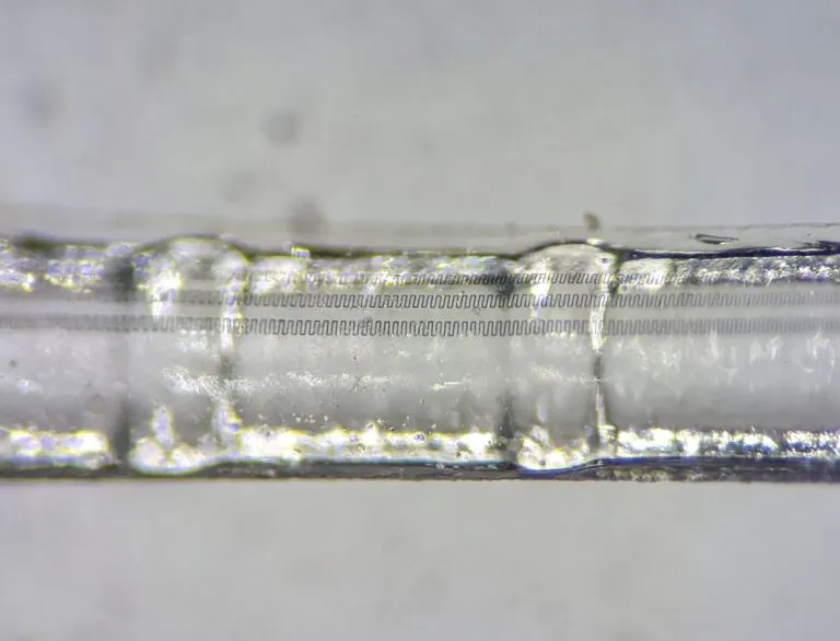 Macro view of serpentine FlexDetect sensor traces running along a cochlear implant electrode.